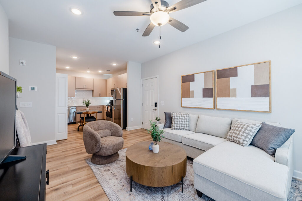 Modern apartment living room with a sectional sofa and open kitchen.