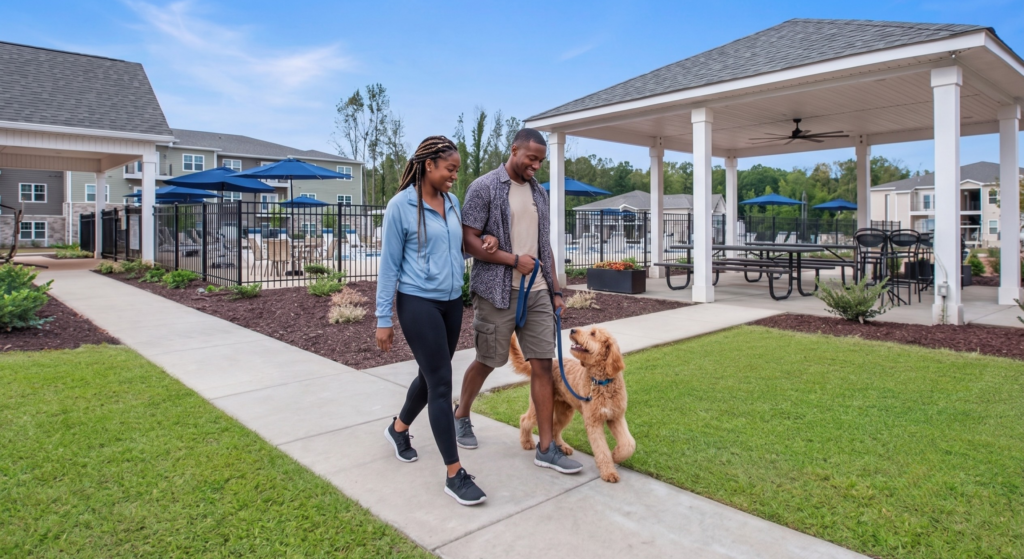 Couple walking their dog at Preston Park Apartments in Burlington, Nc